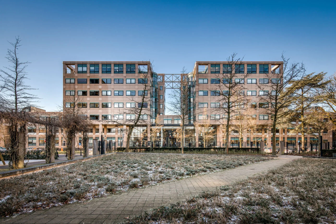 Kantoorgebouw aan de Arthur van Schendelstraat met een besneeuwd plantsoen en wandelpad op de voorgrond.